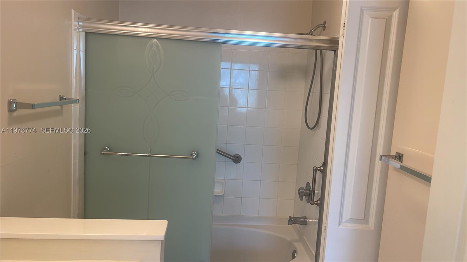 6020 West Sample Road, Unit 207 Coral Springs, FL 33067 - Photo 14 of 17 a bathroom with a glass shower door