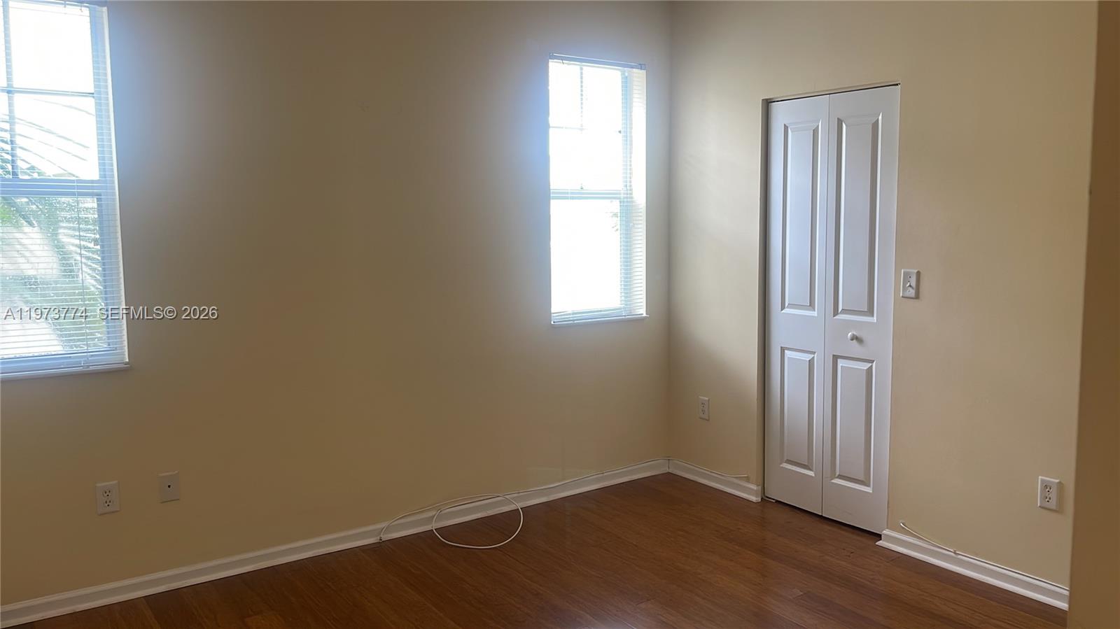 6020 West Sample Road, Unit 207 Coral Springs, FL 33067 - Photo 4 of 17 an empty room with wooden floor and windows