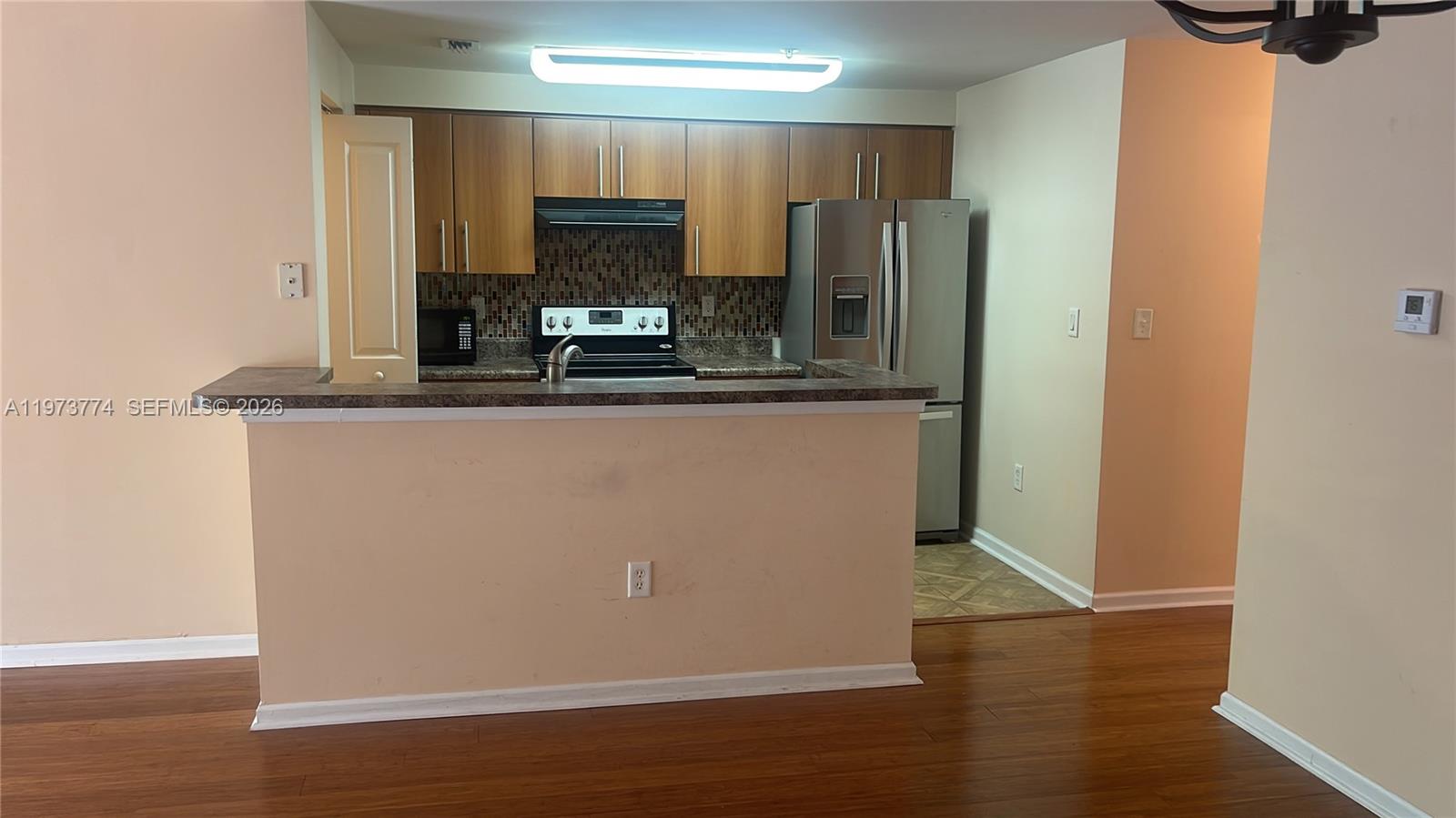 6020 West Sample Road, Unit 207 Coral Springs, FL 33067 - Photo 9 of 17 a view of a kitchen with wooden floor