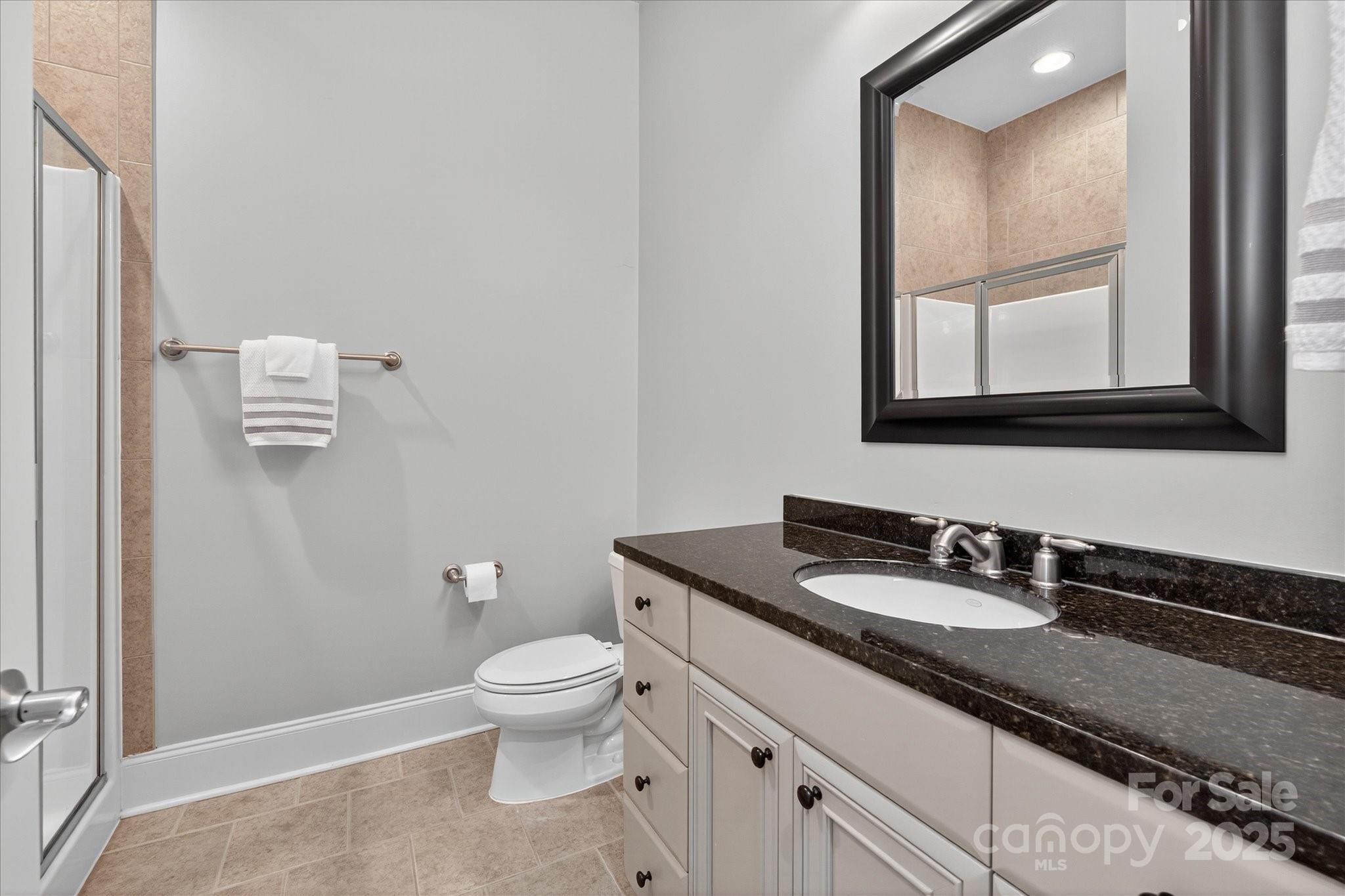 9614 Wheatfield Road Charlotte, NC 28277 - Photo 36 of 47 a bathroom with a granite countertop toilet sink and mirror