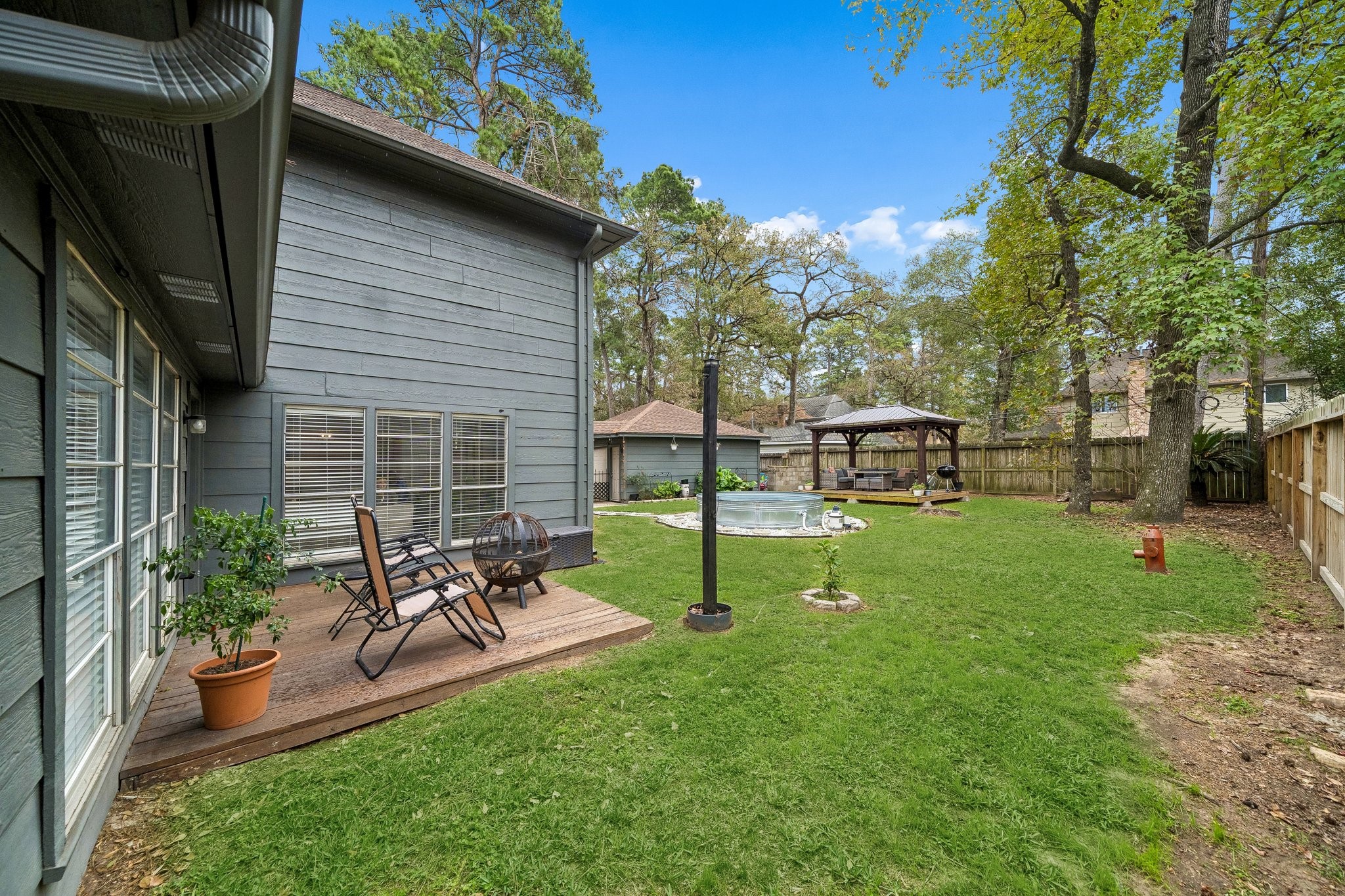 3315 Candleridge Drive Spring, TX 77388 - Photo 11 of 25 Discover your perfect retreat with this inviting backyard showcasing a charming wood deck, lush greenery, and a cozy gazebo, ideal for relaxation and outdoor gatherings.