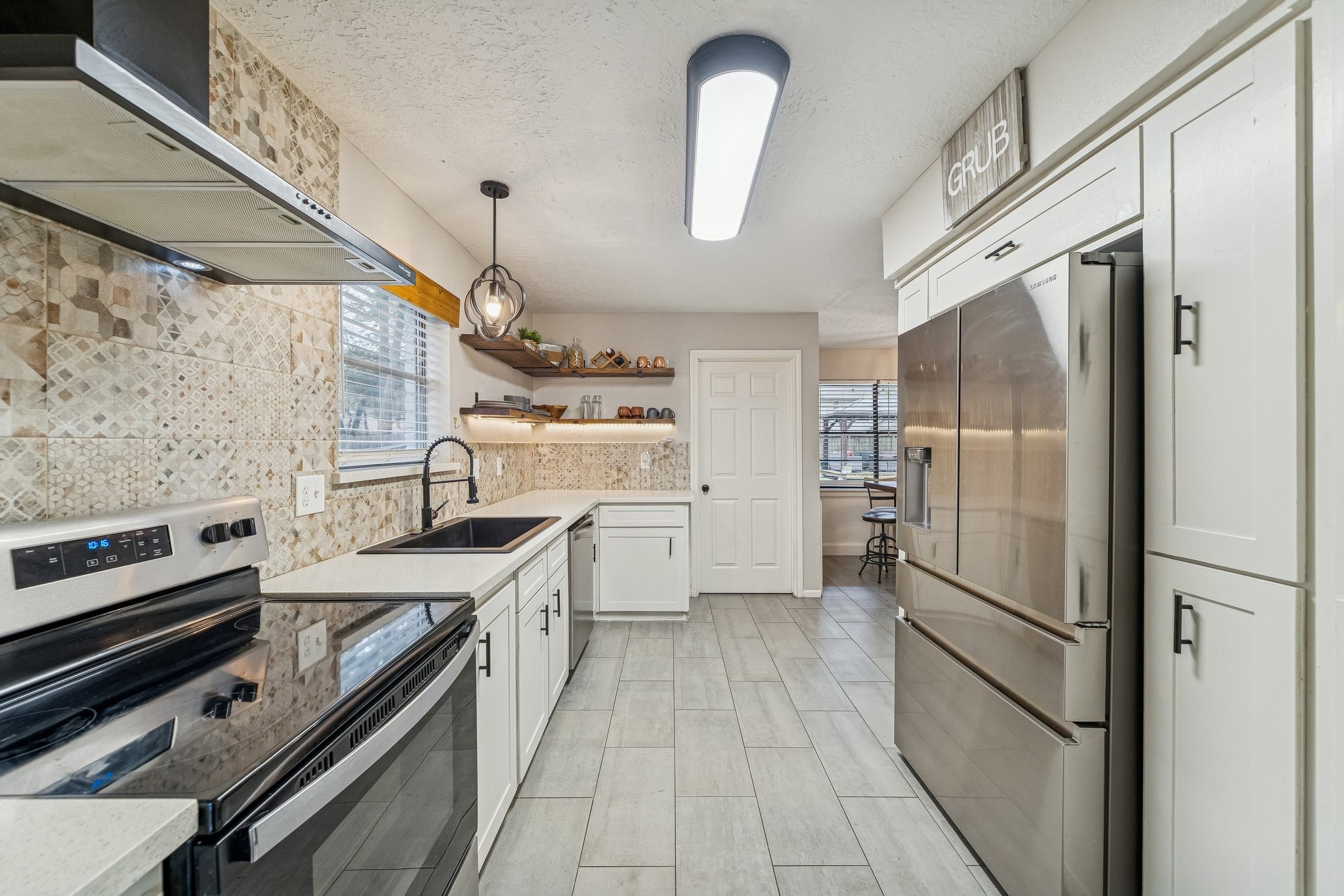 3315 Candleridge Drive Spring, TX 77388 - Photo 6 of 25 This modern kitchen boasts sleek quartz countertops and elegant tile flooring, offering a perfect blend of style and functionality.