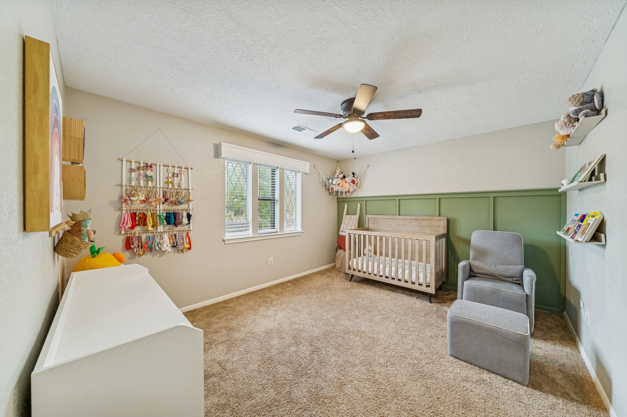 3315 Candleridge Drive Spring, TX 77388 - Photo 9 of 25 This charming nursery, featuring a soothing color scheme and a convenient ceiling fan for comfort, offers a cozy and stylish space for your little one.
