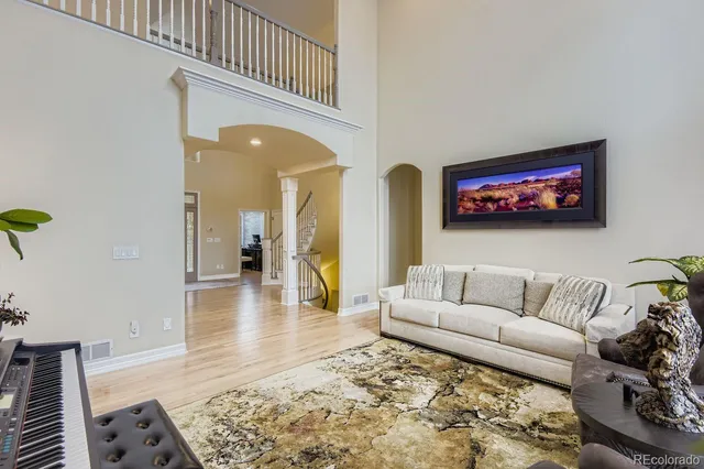 a view of a dining room and livingroom with furniture wooden floor a chandelier