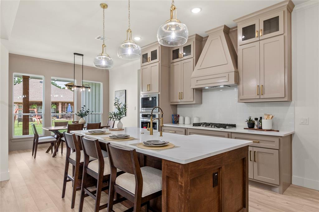 a kitchen with a dining table chairs sink and stove