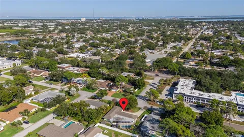 an aerial view of residential houses with outdoor space and trees