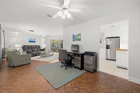 a living room with furniture and a dining table with kitchen appliances