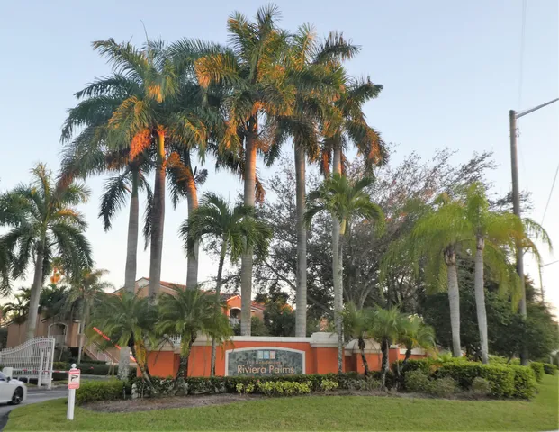 a view of a white house with a palm trees