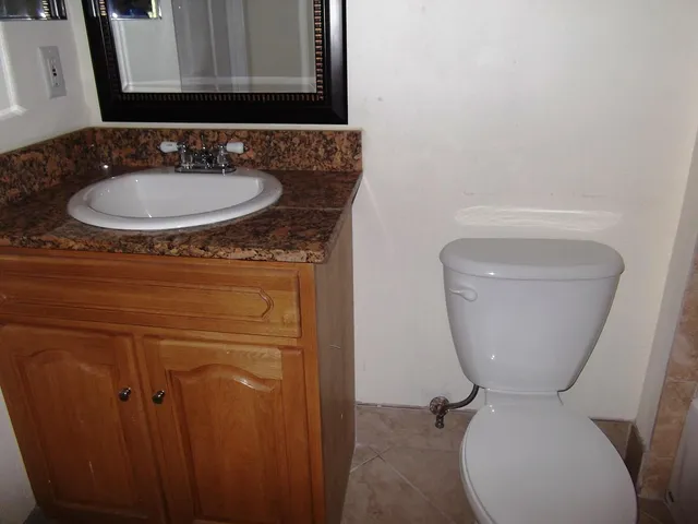 a bathroom with a toilet sink and mirror