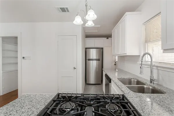 a kitchen with stainless steel appliances granite countertop a sink stove and refrigerator