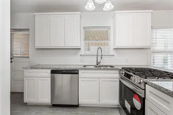 a kitchen with white cabinets and appliances