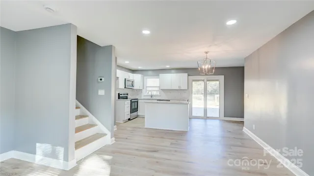 a kitchen with granite countertop white cabinets sink and stainless steel appliances
