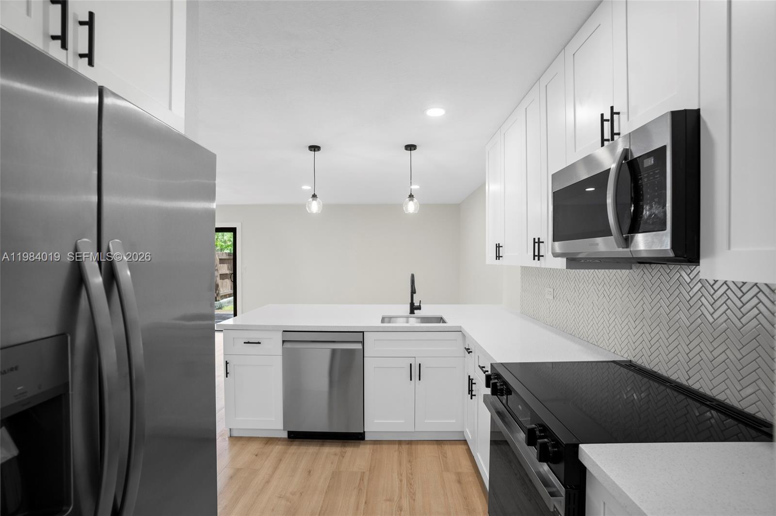 28015 Southwest 143rd Court Homestead, FL 33033 - Photo 3 of 29 a kitchen that has a sink stainless steel appliances a refrigerator and a counter top space
