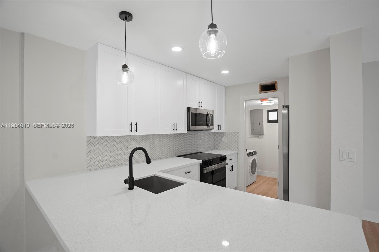28015 Southwest 143rd Court Homestead, FL 33033 - Photo 4 of 29 a large kitchen with stainless steel appliances kitchen island a sink a table and chairs