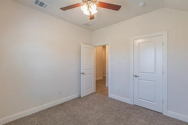 an empty room with a window and a fan
