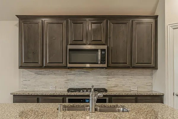 a kitchen with granite countertop a sink and a stove top oven