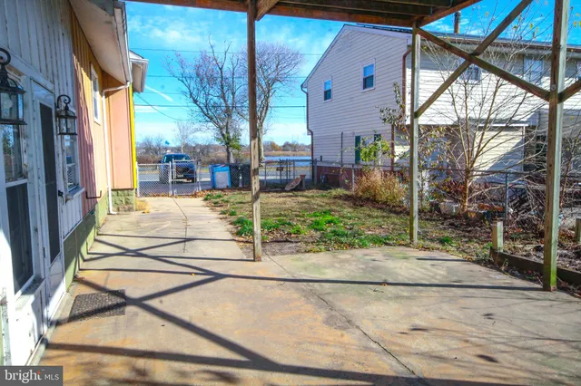 a view of a patio with a table and chairs and floor to ceiling window and wooden fence