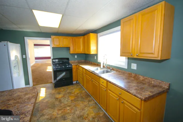 a kitchen with stainless steel appliances granite countertop a sink a stove and a refrigerator
