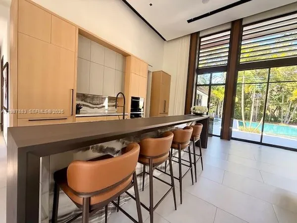 a living room with furniture a chandelier fan and a large window