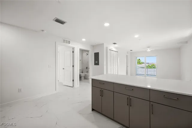 a kitchen with stainless steel appliances a refrigerator sink and white cabinets