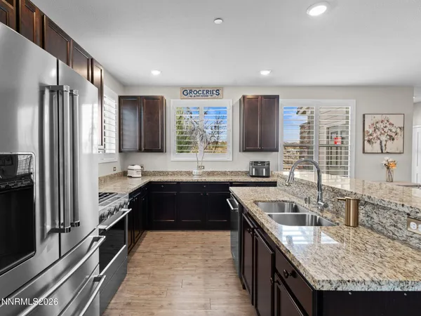 a kitchen with stainless steel appliances granite countertop a refrigerator stove and sink