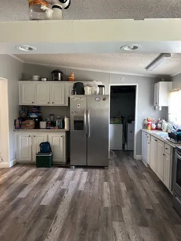 a kitchen with kitchen island a counter top space a sink and cabinets