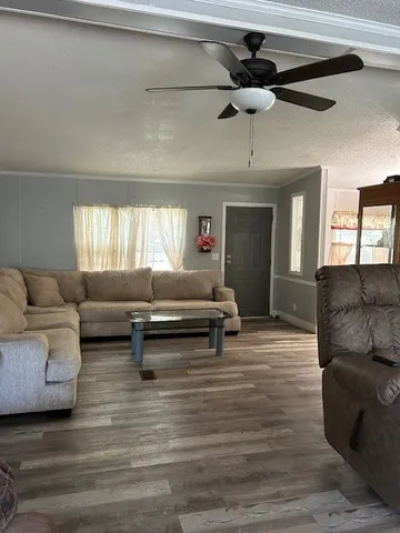 a living room with furniture and a wooden floor