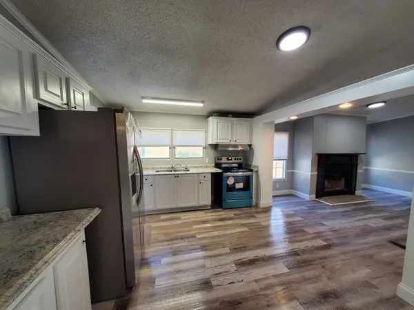 a kitchen with a refrigerator and a fireplace