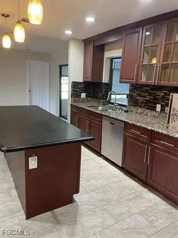 a kitchen with stainless steel appliances granite countertop a stove a sink dishwasher and a microwave oven with large cabinets