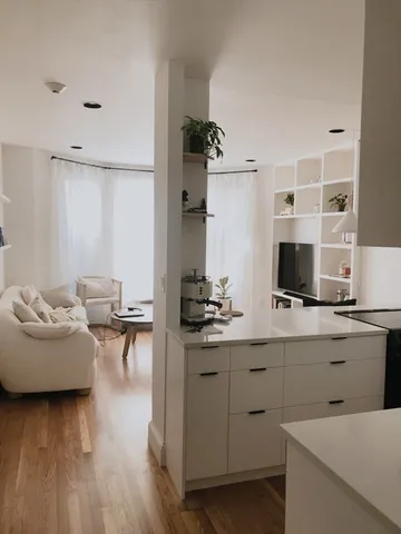 a living room with furniture and view of kitchen