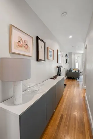 a large white kitchen with a sink and wooden floor