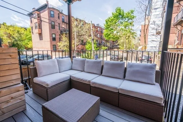 a rooftop view with two chairs and a potted plant