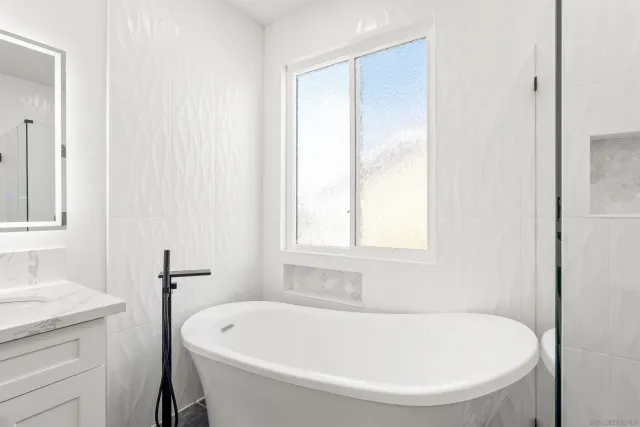 a white bath tub sitting next to a white sink