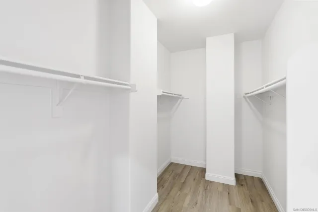 a view of walk in closet with wooden floor