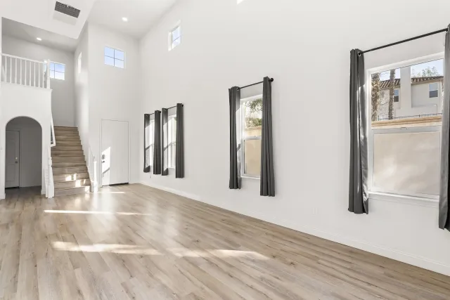 a view of an empty room with glass door and chandelier