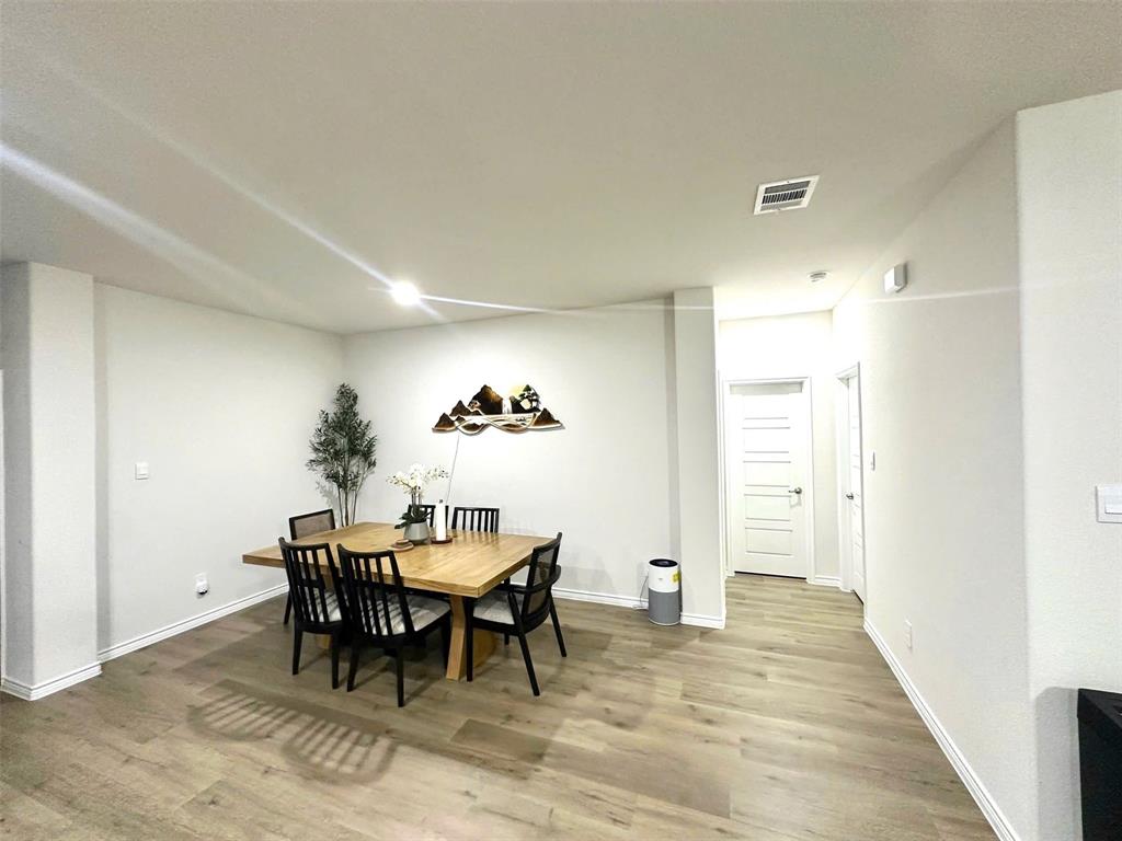 324 Revolution Road Fate, TX 75189 - Photo 2 of 15 Spacious room featuring wood-finish flooring, white baseboards, and neutral wall tones