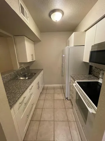 a kitchen with stainless steel appliances granite countertop a sink and a stove