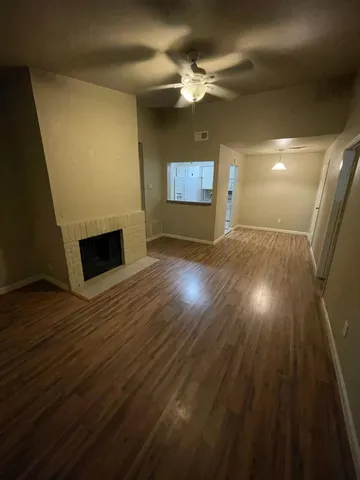 a view of a livingroom with wooden floor and a ceiling fan