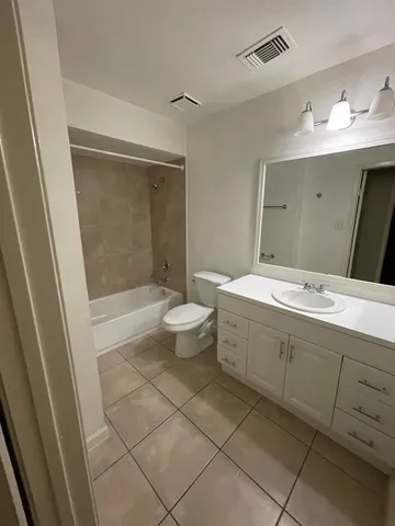 a spacious bathroom with a double vanity sink toilet and a mirror