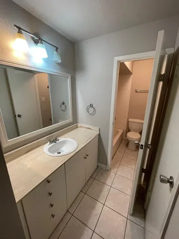 a spacious bathroom with a granite countertop sink a mirror and a vanity