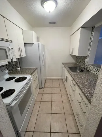 a kitchen with a sink a stove and a refrigerator