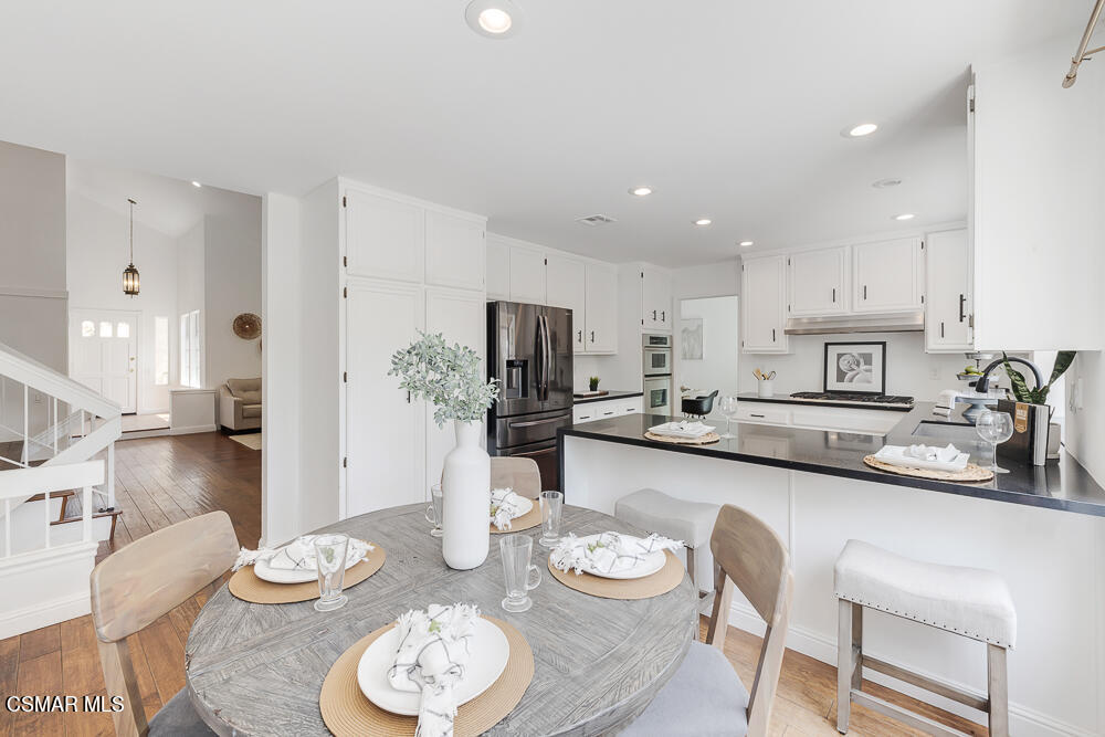 4035 Cliffrose Avenue Moorpark, CA 93021 - Photo 11 of 43 a kitchen with stainless steel appliances kitchen island granite countertop a dining table and chairs