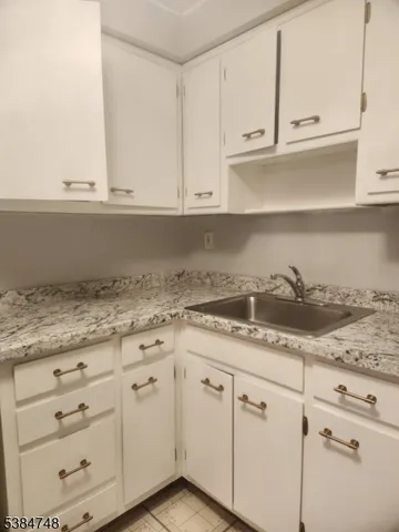 a kitchen with granite countertop white cabinets and a stove