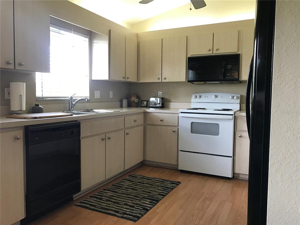 11879 Southwest 137th Loop Dunnellon, FL 34432 - Photo 25 of 37 a kitchen with a sink stove and microwave