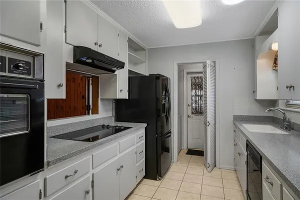 a kitchen with granite countertop stainless steel appliances a stove and a refrigerator