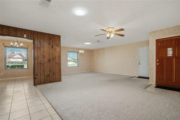 an empty room with closet and a chandelier fan
