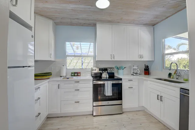 a kitchen with cabinets appliances and a window