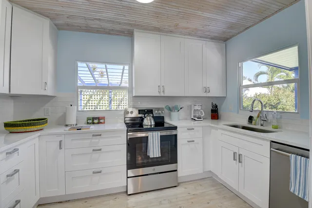 a kitchen with white cabinets and white appliances