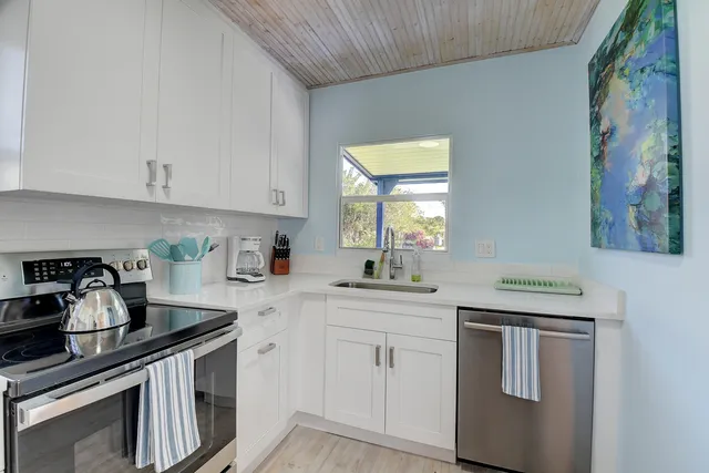 a kitchen with granite countertop white cabinets and white appliances