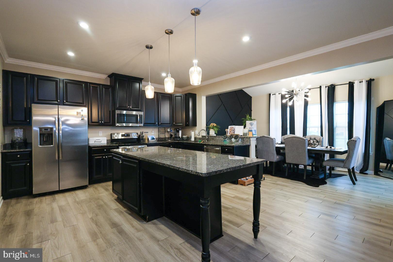 152 Tywyn Drive Middletown, DE 19709 - Photo 8 of 25 a kitchen with stainless steel appliances granite countertop a refrigerator a sink dishwasher a stove and a dining table with wooden floor